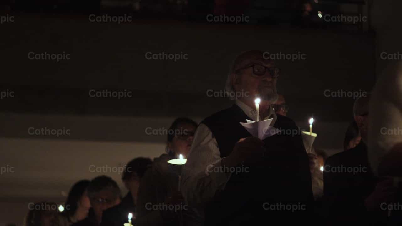 La comunidad reza con velas encendidas - Banco de vídeos católicos - Fotografía por Almures Studio