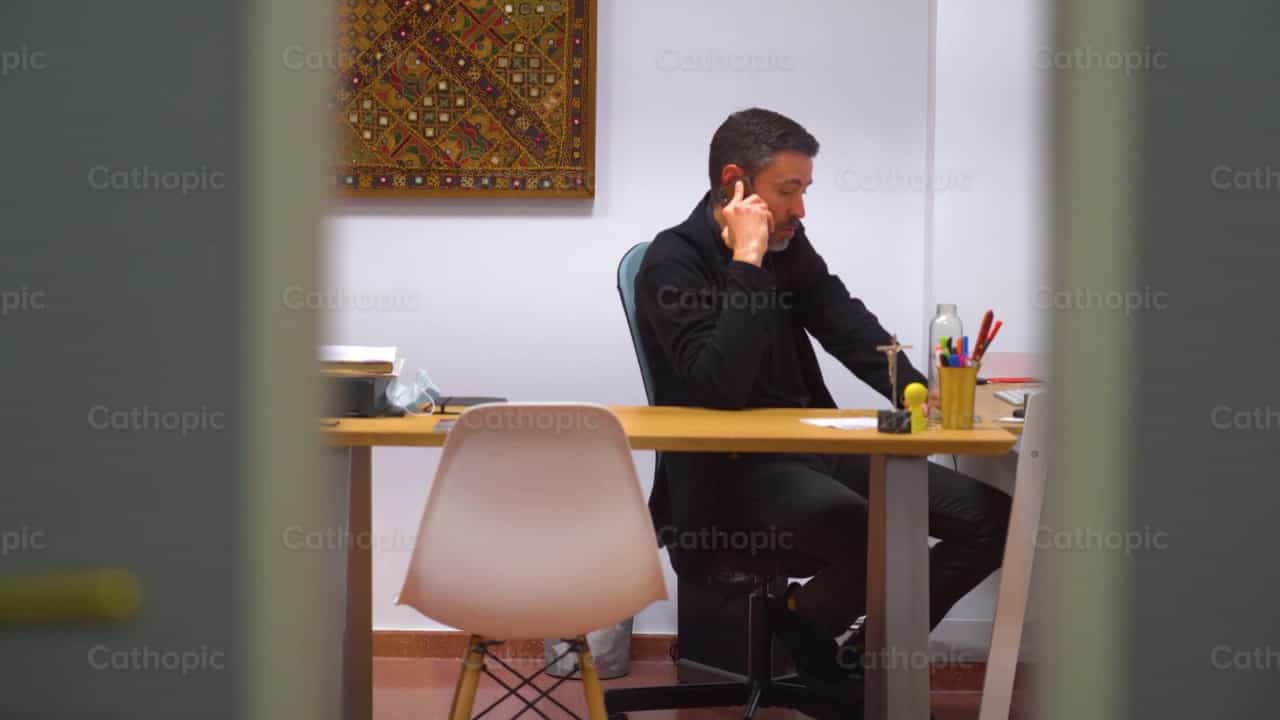 Sacerdote trabajando en la oficina - Banco de vídeos católicos - Fotografía por Cathopic