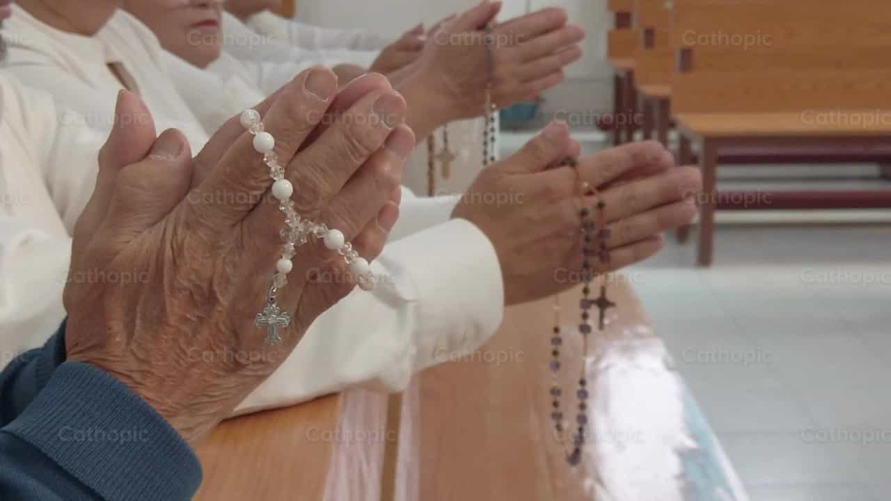 People praying with a rosary of the Virgin Mary - Catholic stock videos - Photo by Susana Mondragón