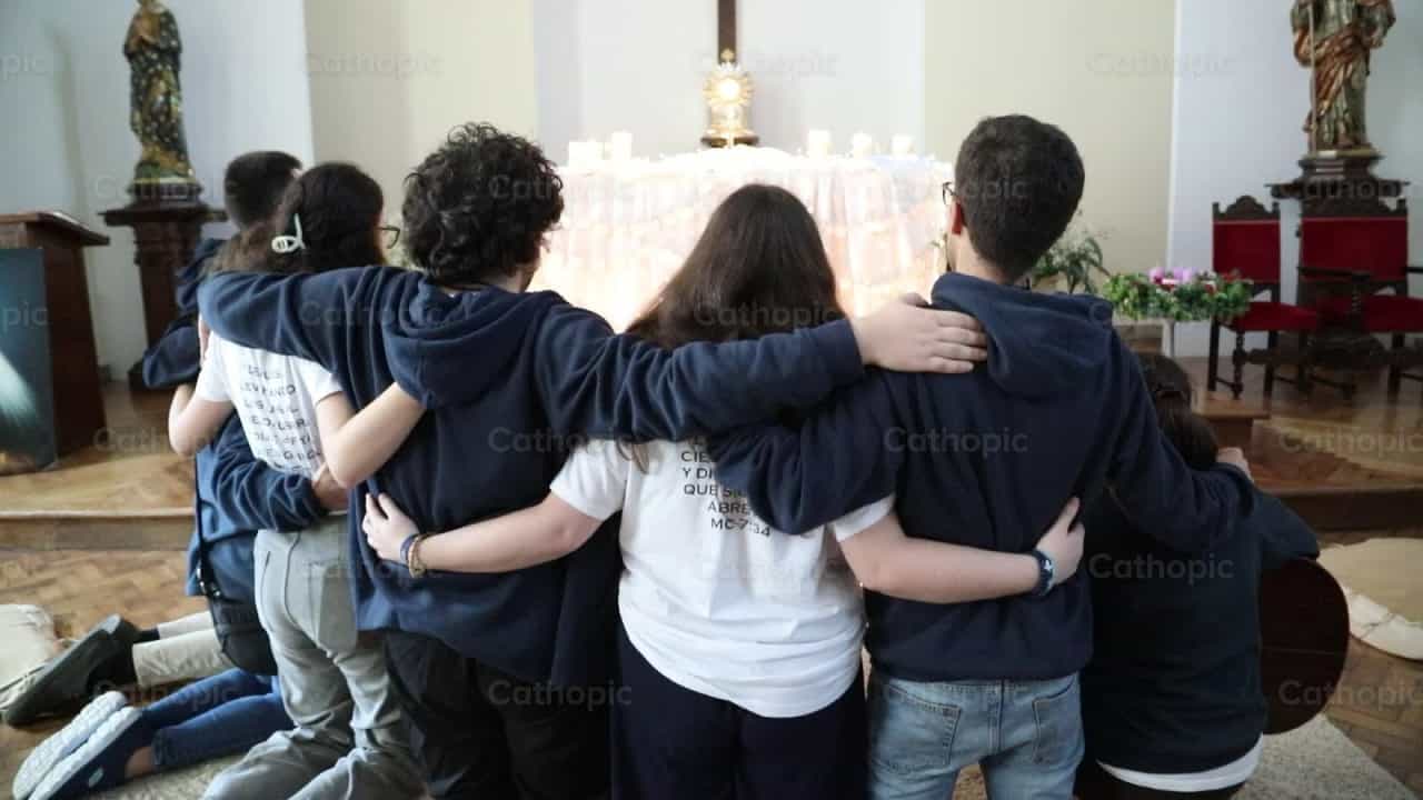 Jóvenes abrazados rezando frente al Santísimo - Banco de vídeos católicos - Fotografía por Yandry Fernández Perdomo