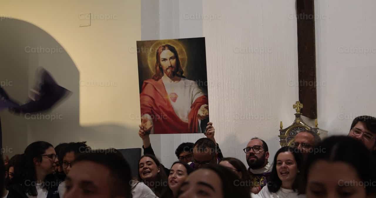 Joven carga imagen del Sagrado Corazón en retiro - Banco de vídeos católicos - Fotografía por Yandry Fernández Perdomo