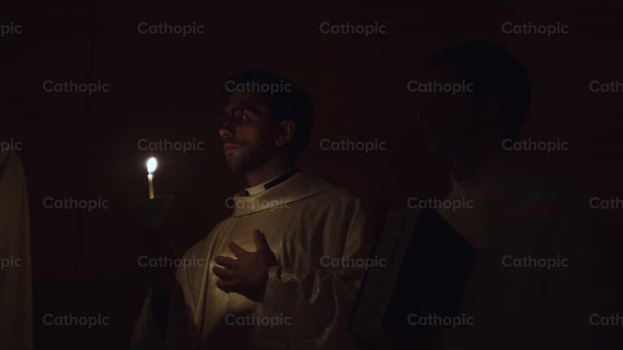 Sacerdote con vela encendida en el Fuego Sagrado - Banco de vídeos católicos - Fotografía por Almures Studio