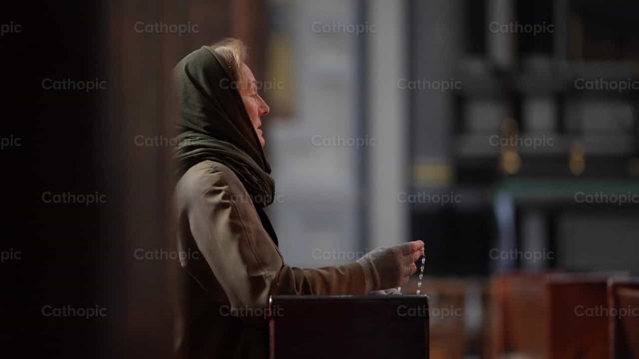 Mujer rezando de rodillas - Banco de vídeos católicos - Fotografía por Álvaro García