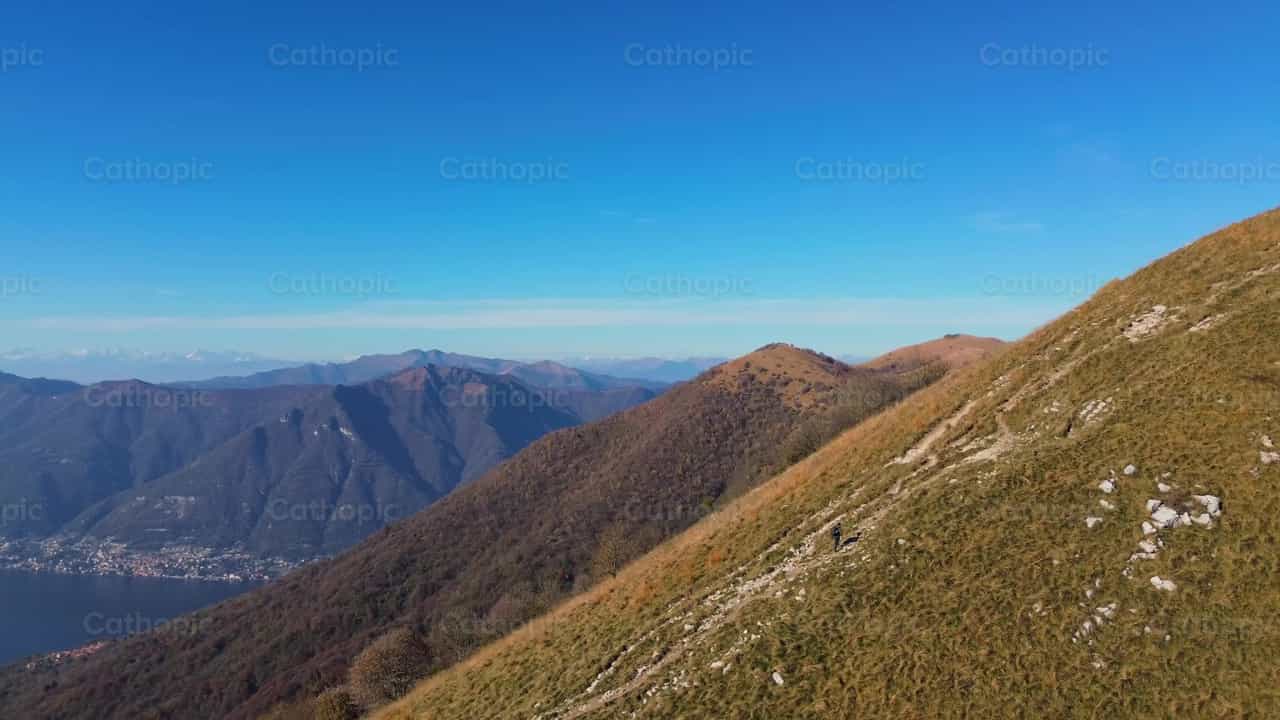 Hombre caminando hacia la cima de la montaña - Banco de vídeos católicos