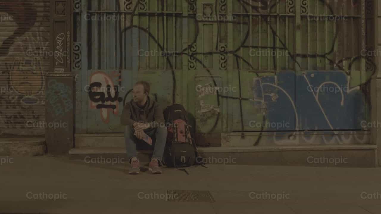 Jovem Sentado num Meio-Fio - Vídeos católicos de stock