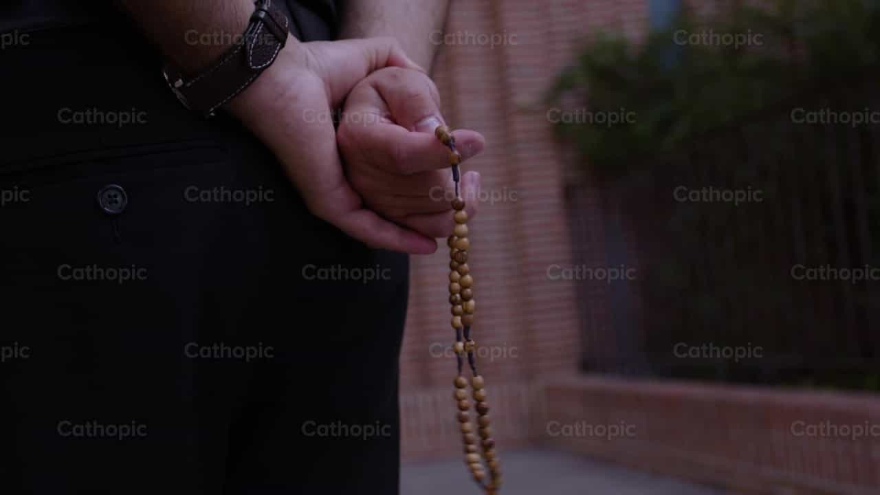 Sacerdote rezando el Santo Rosario - Banco de vídeos católicos - Fotografía por Almures Studio