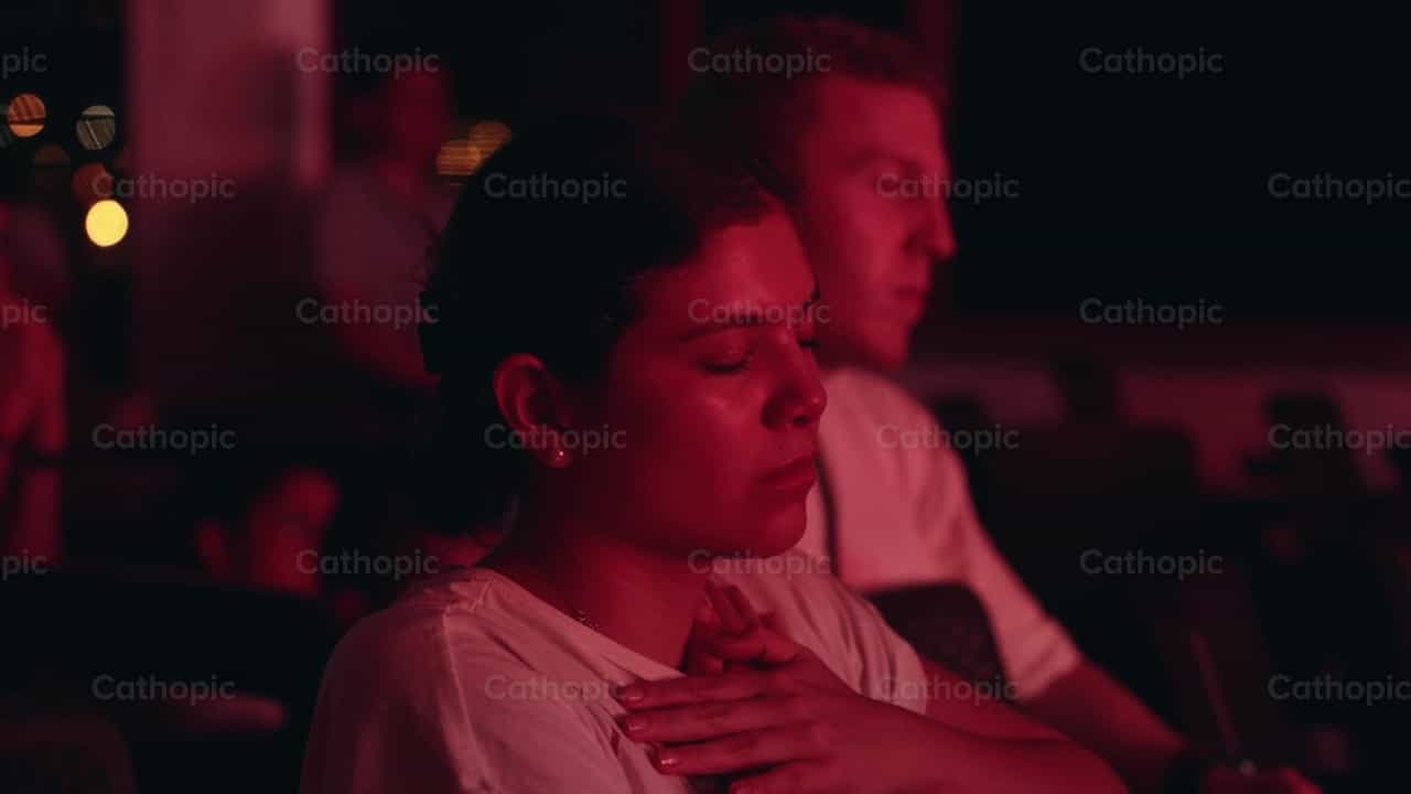Mujer orando en Adoración Eucarística - Banco de vídeos católicos - Fotografía por Carlos Gaviria