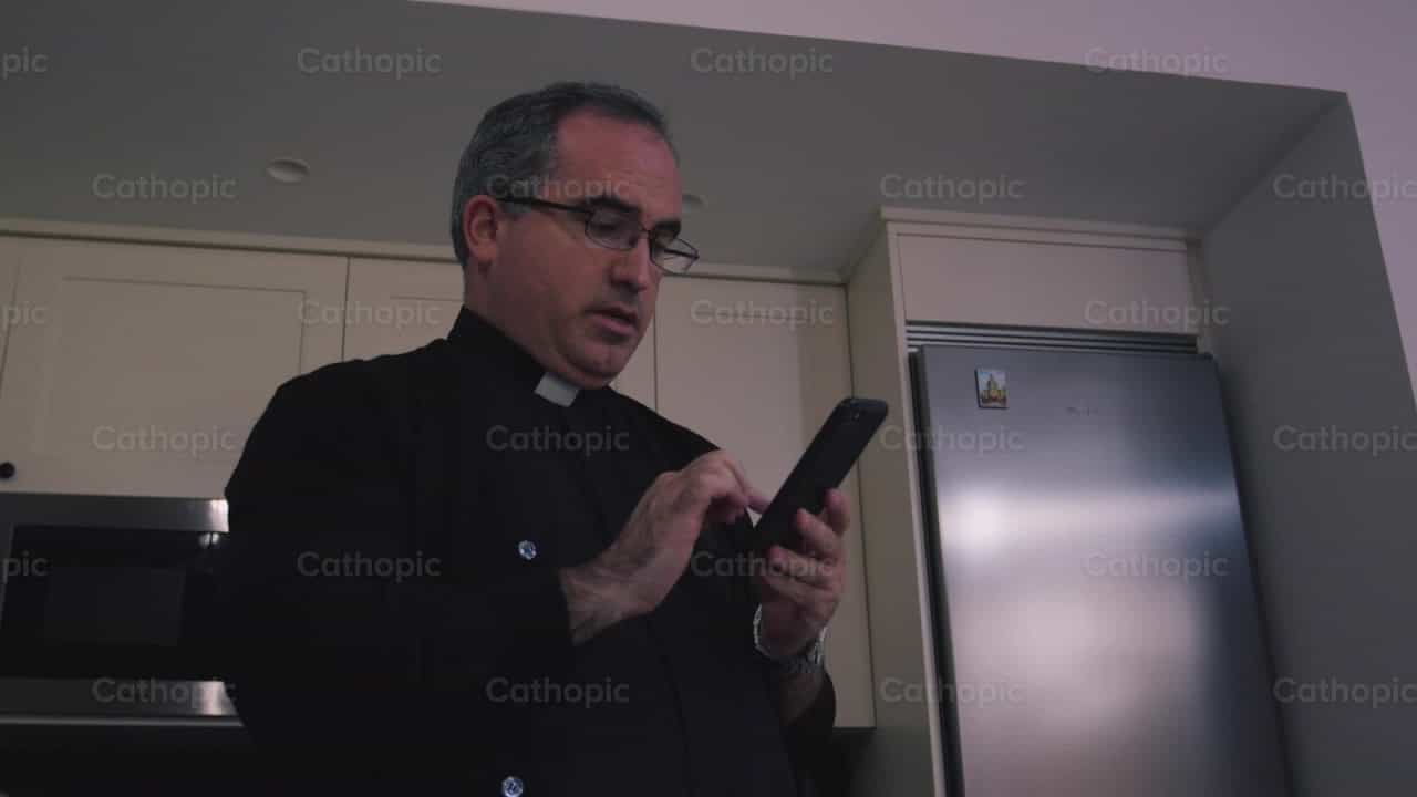 Sacerdote llamando por telefono - Banco de vídeos católicos - Fotografía por Almures Studio