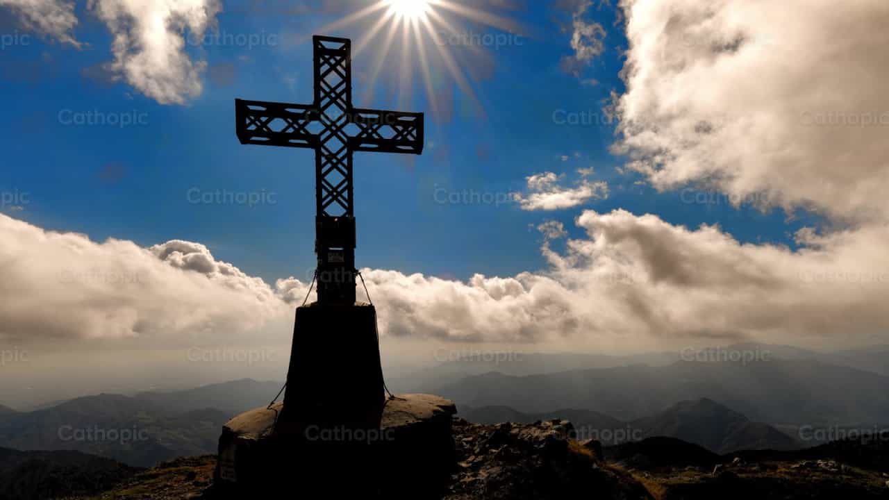 Cruz en la cima de una montaña con nubes en movimiento - Banco de vídeos católicos - Fotografía por Michelangelo Oprandi
