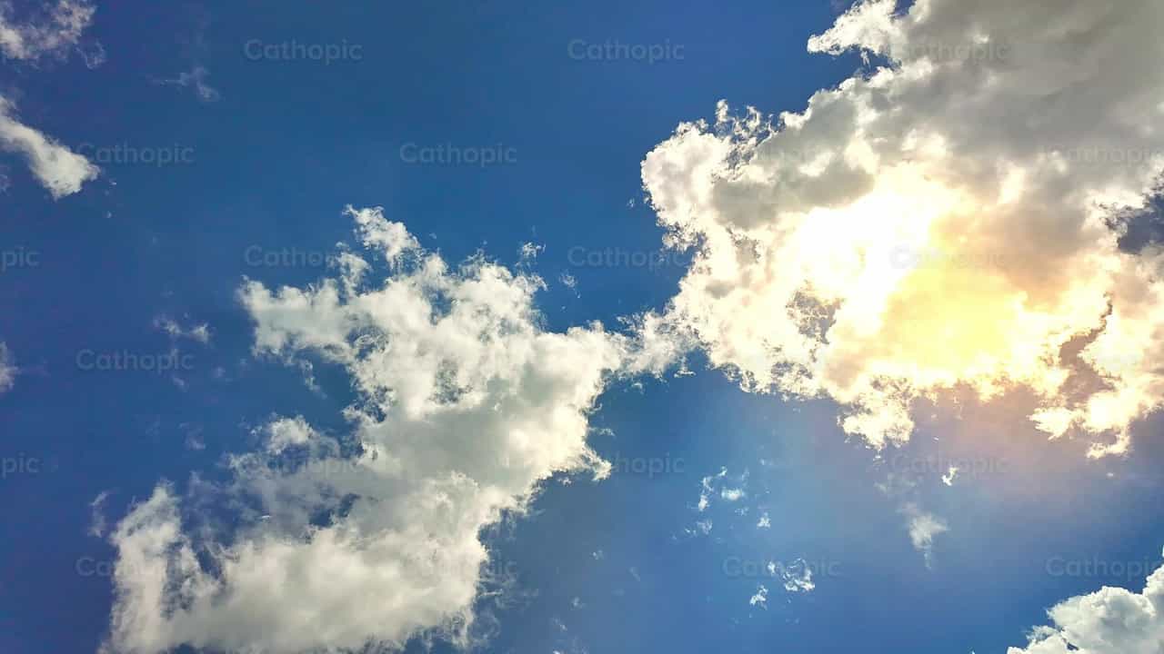 Lapso de tiempo de nubes blancas iluminadas por el sol flotando en un cielo despejado - Banco de vídeos católicos - Fotografía por Michelangelo Oprandi