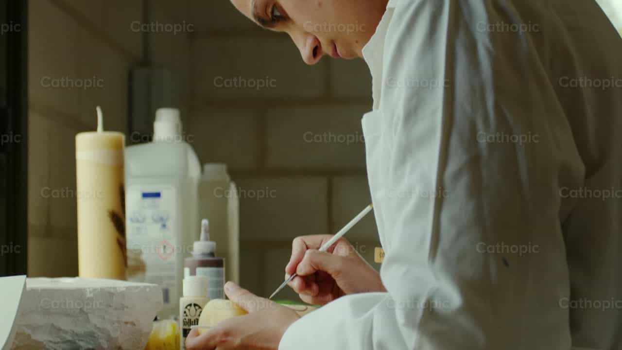 Augustinian Nun painting a Candle - Banco de vídeos católicos - Fotografía por Almures Studio