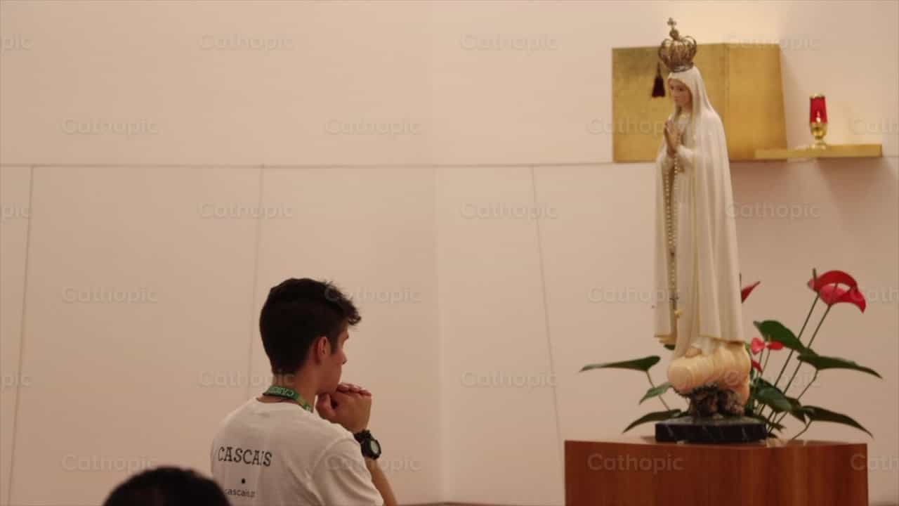 Joven orando frente a Virgen de Fatima - Banco de vídeos católicos - Fotografía por Saul Ibarra