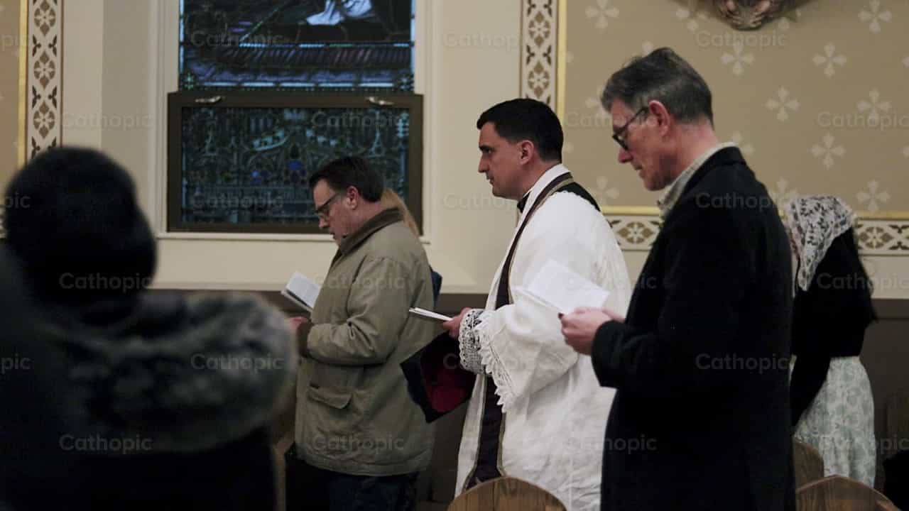 El sacerdote camina hacia la siguiente estación del viacrucis - Banco de vídeos católicos - Fotografía por Carlos Sierra