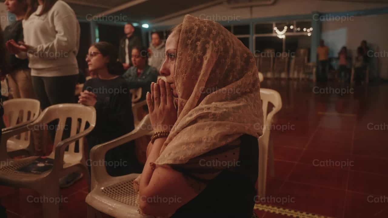 Mujer arrodillada con velo orando y manos unidas - Banco de vídeos católicos - Fotografía por Carlos Gaviria