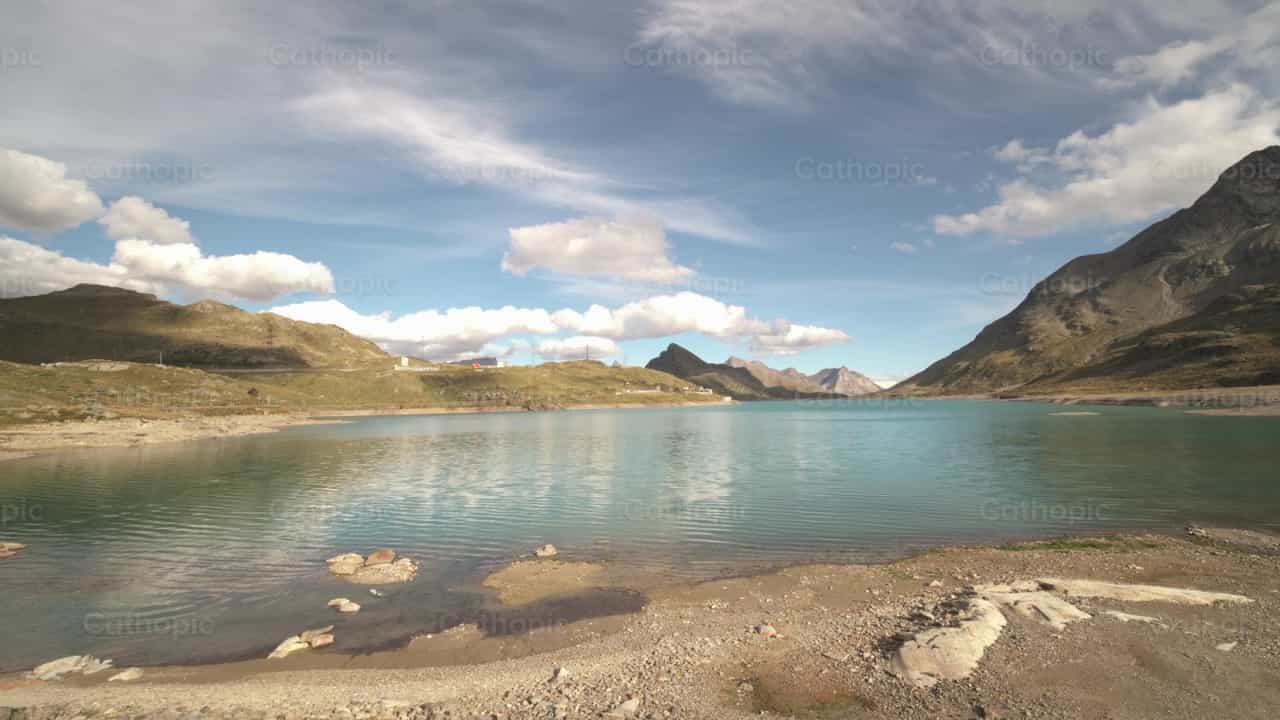 Lago de montanha calmo sob céu azul com nuvem branca - Vídeos católicos de stock - Foto de Michelangelo Oprandi