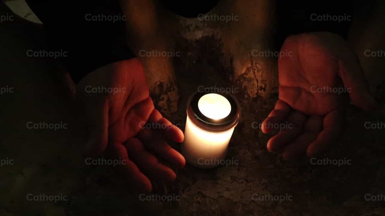 Vela encendida y manos - Banco de vídeos católicos