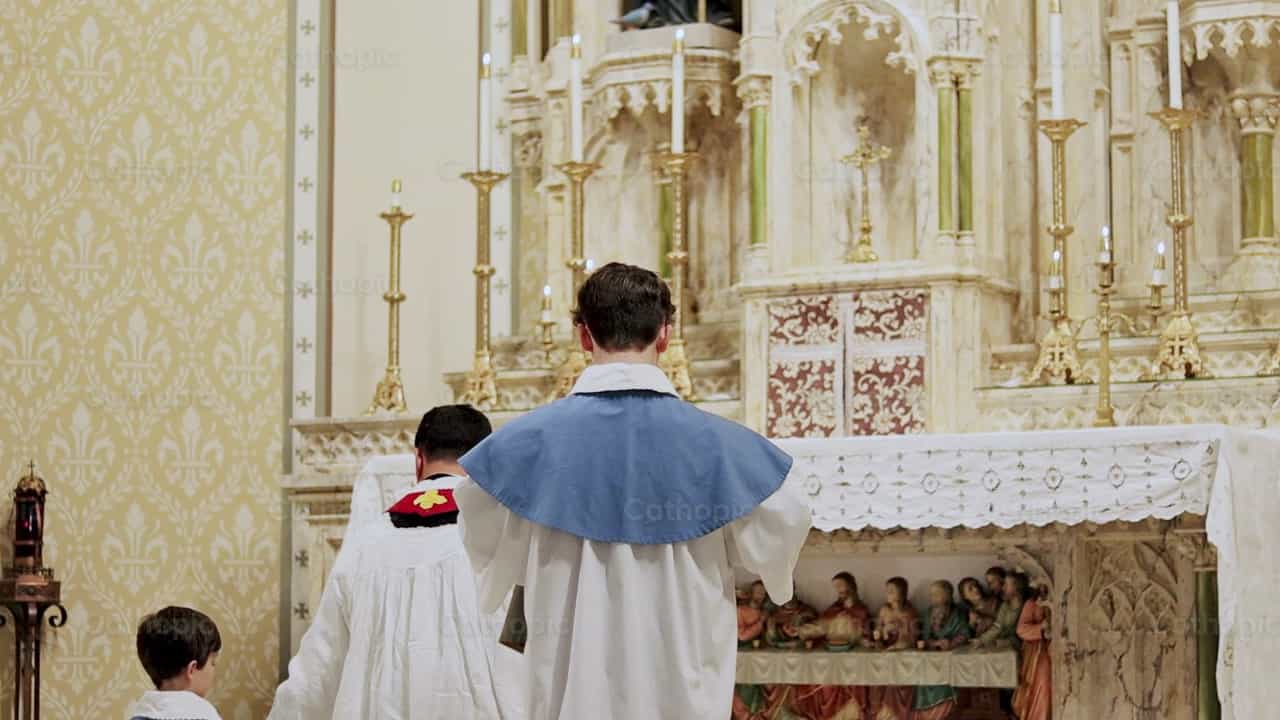 El monaguillo le pone la capa al cura - Banco de vídeos católicos - Fotografía por Carlos Sierra