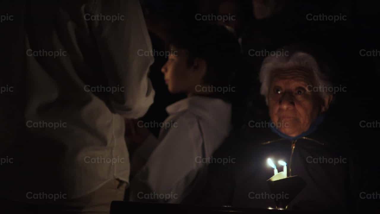 Mujer encendiendo velas en el Fuego Sagrado - Banco de vídeos católicos