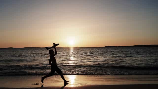 Enfant jouant sur la plage - Images catholiques de stock