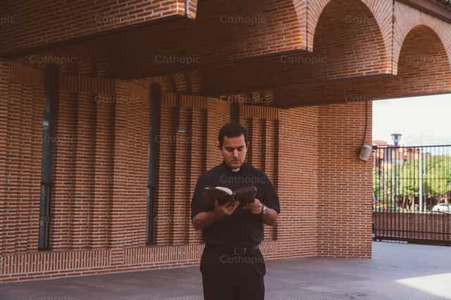 O sacerdote caminha e reza com a Palavra de Deus - Imagens católicas de stock - Foto de Almures Studio