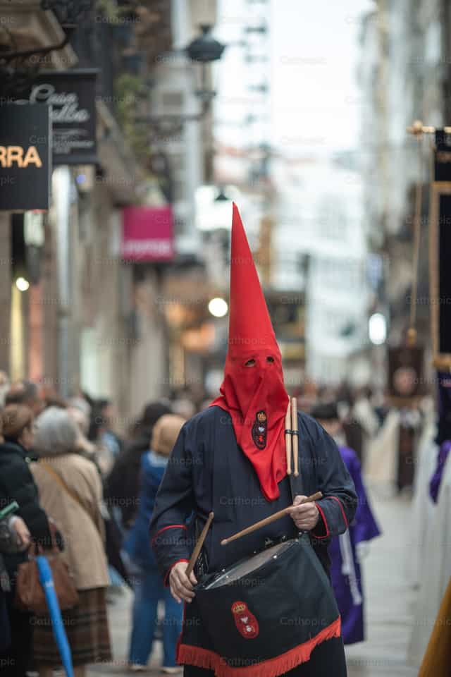 Man met capirote die trom speelt in processie - Katholieke stockfoto's