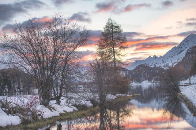 Paysage hivernal enneigé avec un coucher de soleil coloré sur un lac de montagne - Images catholiques de stock - Photo de Michelangelo Oprandi