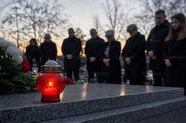 Personnes en deuil près d’une tombe avec lanterne - Images catholiques de stock - Photo de Filip Pleše
