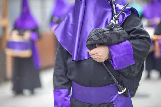 Broeder met capirote die muziek speelt tijdens een processie - Katholieke stockfoto's - Foto door Yandry Fernández Perdomo