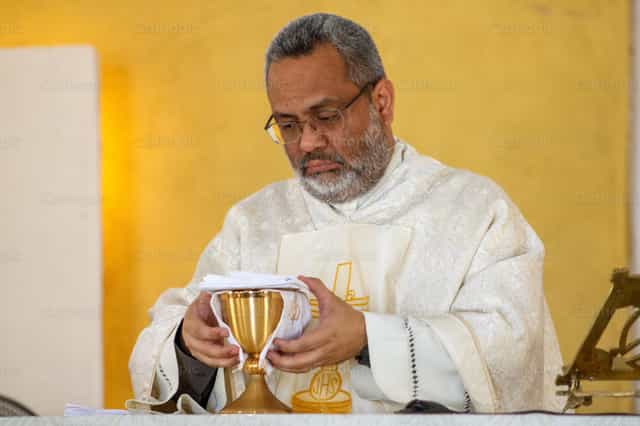 Ein Priester ordnet die heiligen Gefäße - Katholische Stockfotos