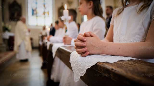 Premières communiantes dans les bancs, les mains en prière - Images catholiques de stock