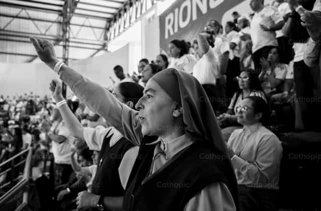Un gesto de oración entre la multitud - Banco de imágenes católicas - Fotografía por Carolina BR