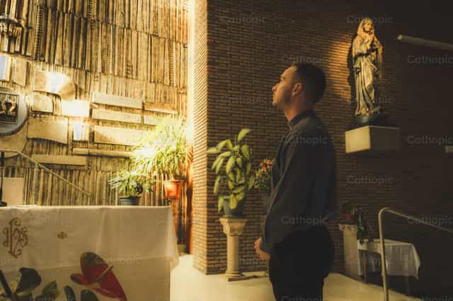 Sacerdote rezando ante el altar - Banco de imágenes católicas