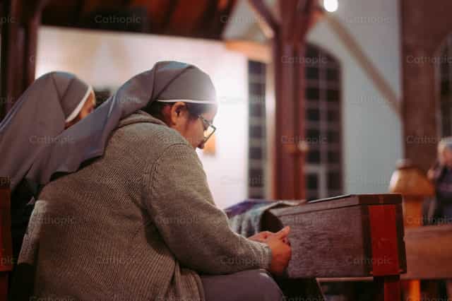 Nun at mass - Catholic stock images