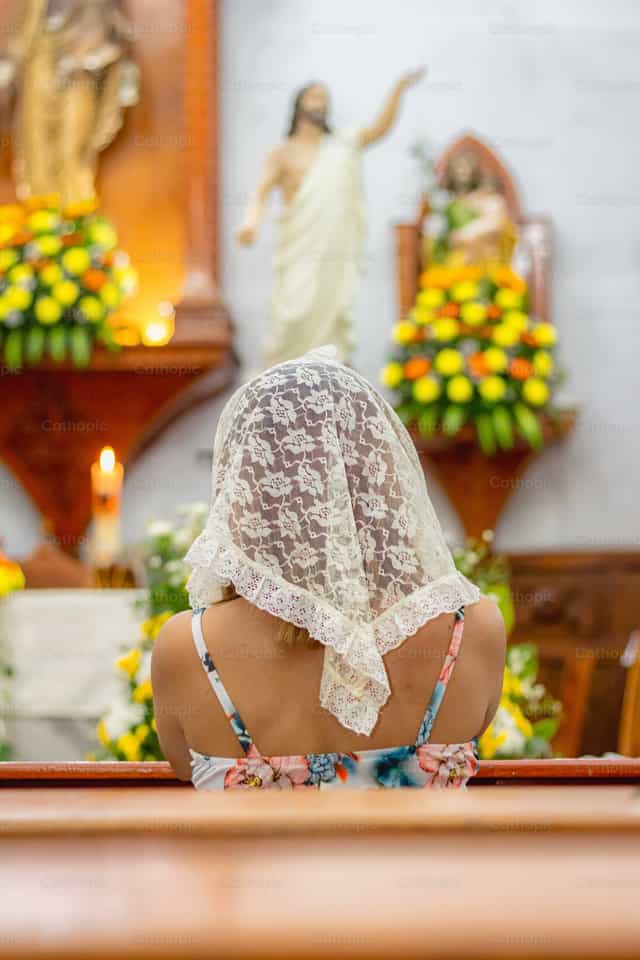 Mulher de véu ajoelhada diante de Jesus - Imagens católicas de stock