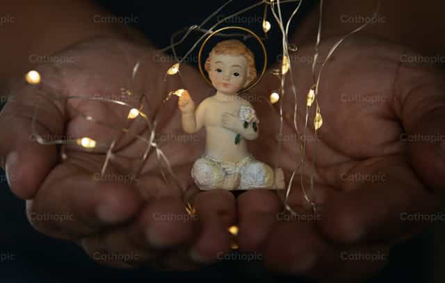 Het kindje Jezus omringd door lichtjes - Katholieke stockfoto's