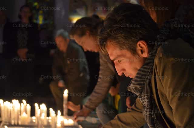 Uomo in preghiera davanti alle candele - Immagini stock cattoliche