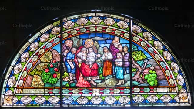 Stained glass window of Jesus preaching to the children - Catholic stock images