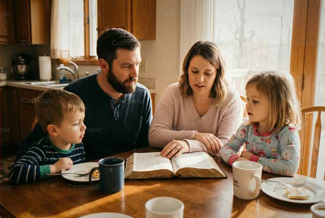 Des parents enseignent les Écritures à leurs enfants à la maison : temps de Bible - Images catholiques de stock - Photo de Noemí Márquez