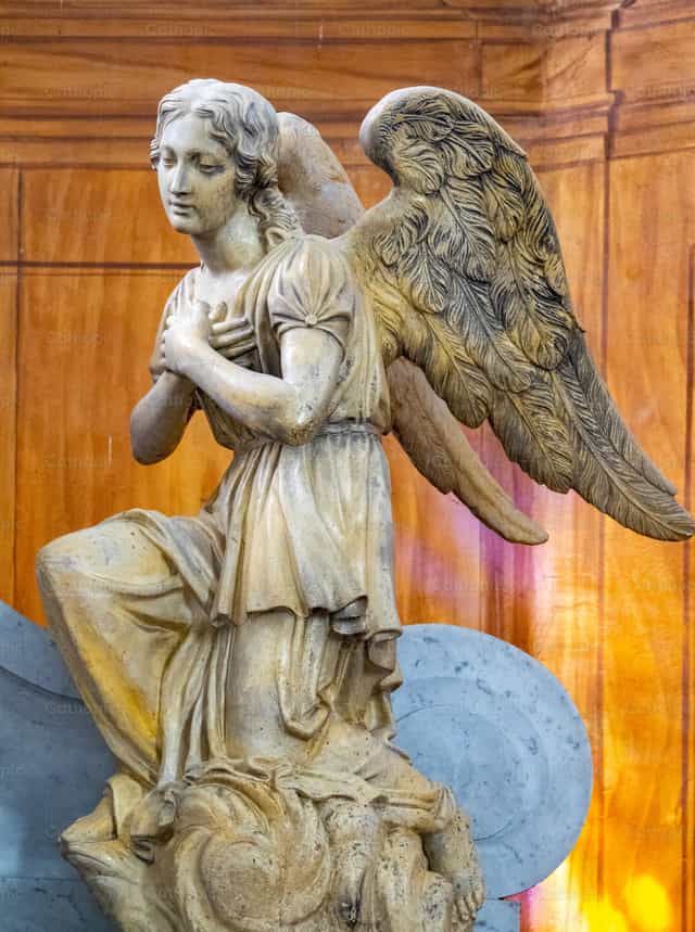 Estatua de un ángel arrodillado en oración - Banco de imágenes católicas - Fotografía por Joan Sutter