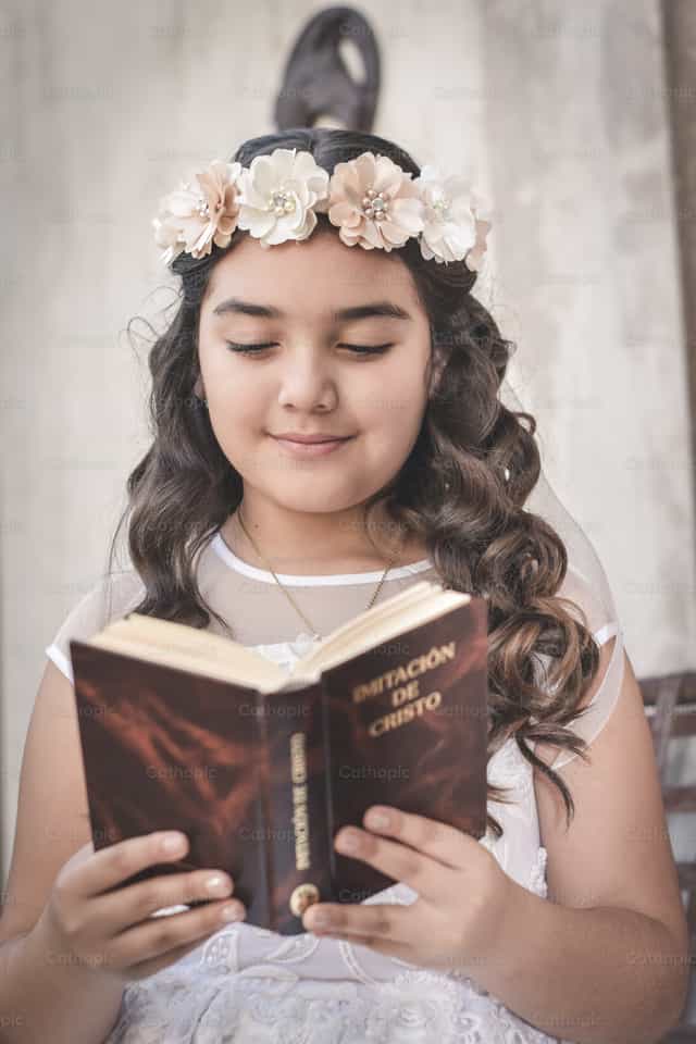 Menina Segurando uma Bíblia - Imagens católicas de stock