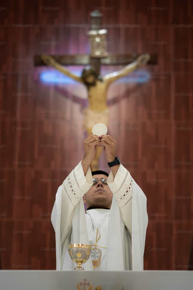 Sacerdote consagrando el pan - Banco de imágenes católicas