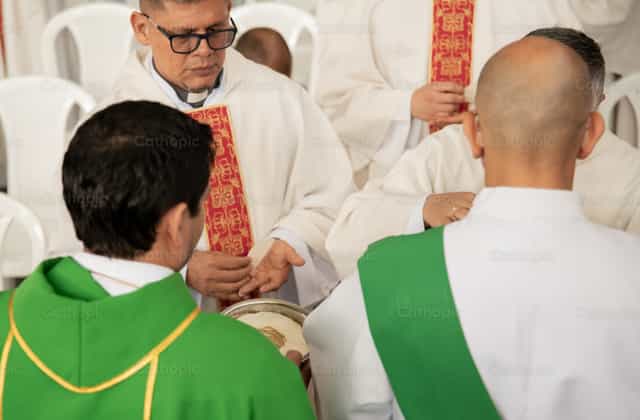 Sacerdotes durante la distribución da comunhão - Imagens católicas de stock