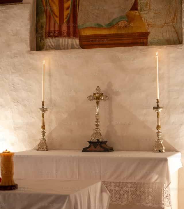 Crucifixo com velas sobre o altar - Imagens católicas de stock