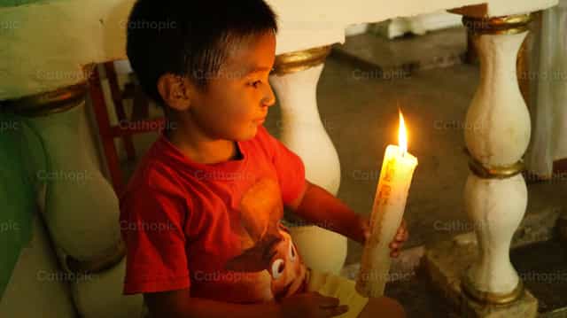 Child with lit candle - Catholic stock images