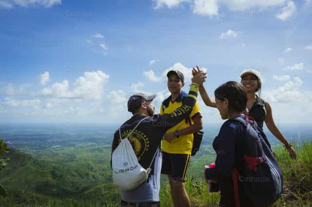 Happy young people at the top of the mountain - Catholic stock images - Photo by Miguel White