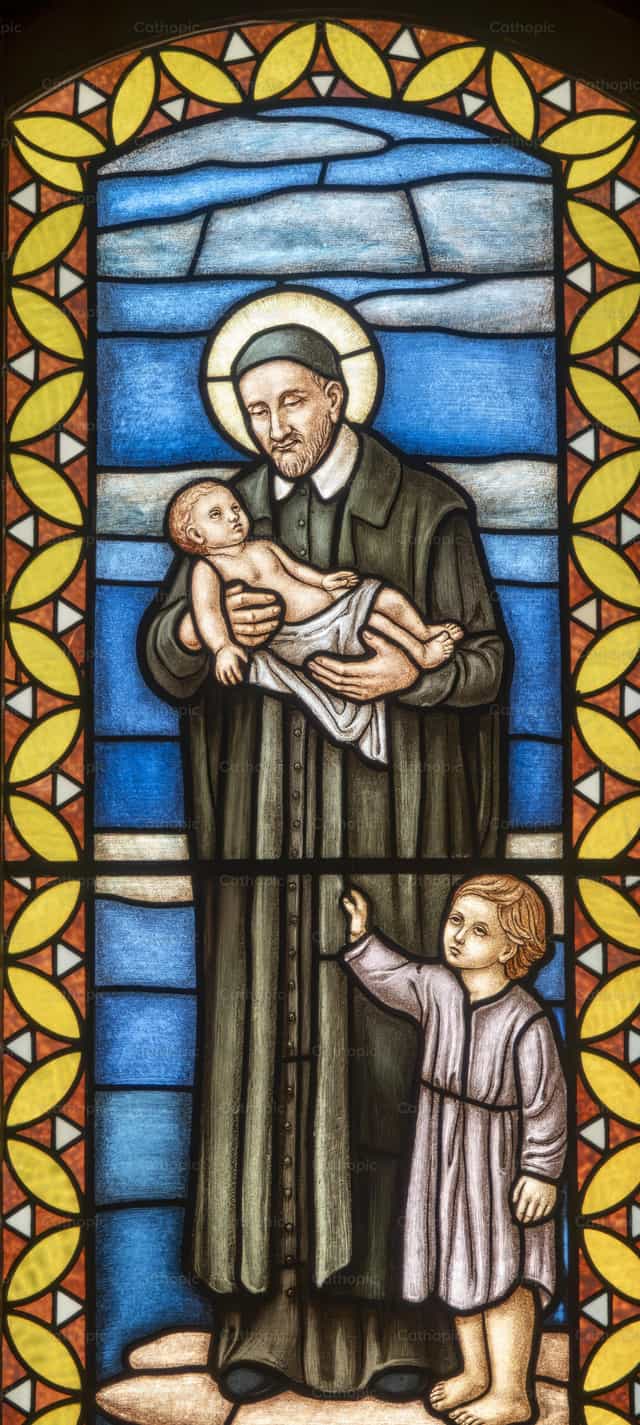 San Vicente de Paúl con un niño en brazos - Banco de imágenes católicas - Fotografía por Joan Sutter