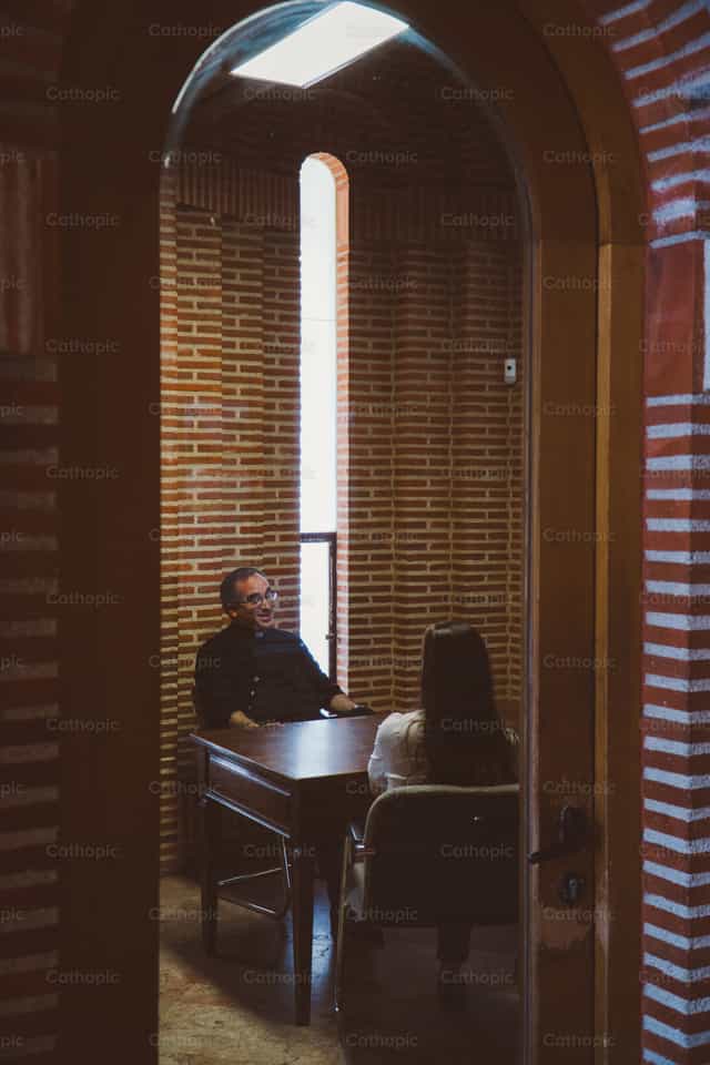 Sacerdote dando direccion espiritual - Banco de imágenes católicas