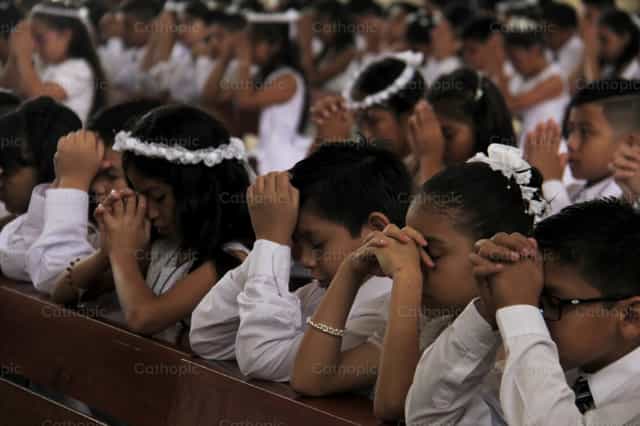 Rezando na sua Primeira Comunhão - Imagens católicas de stock
