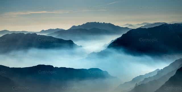 Sommets montagneux enveloppés de brume - Images catholiques de stock