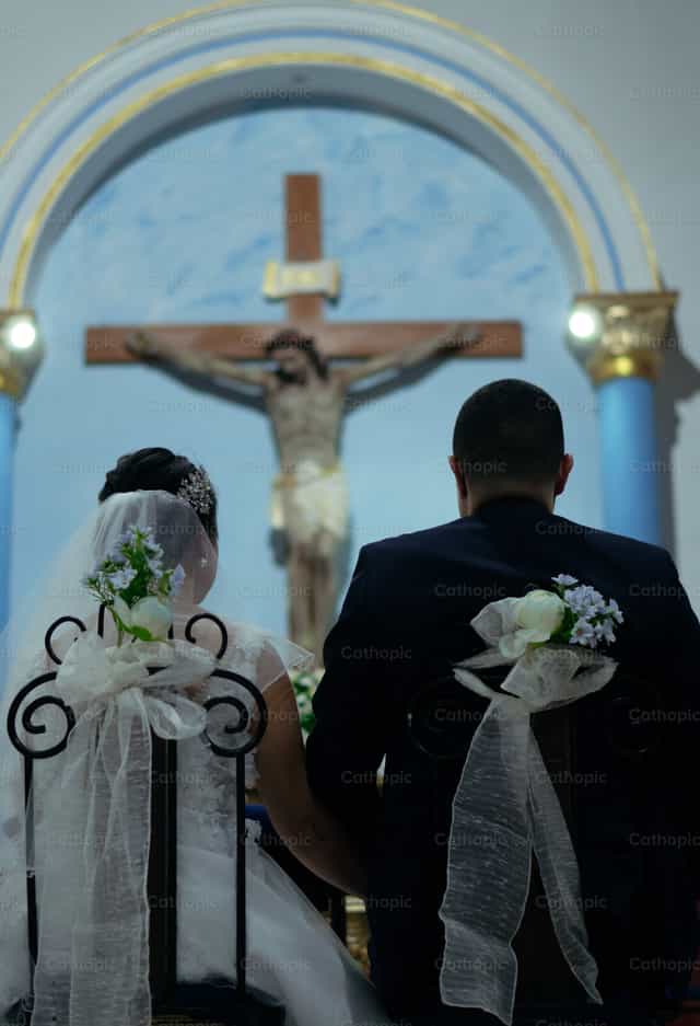 Bride and groom before Jesus at the altar - Catholic stock images